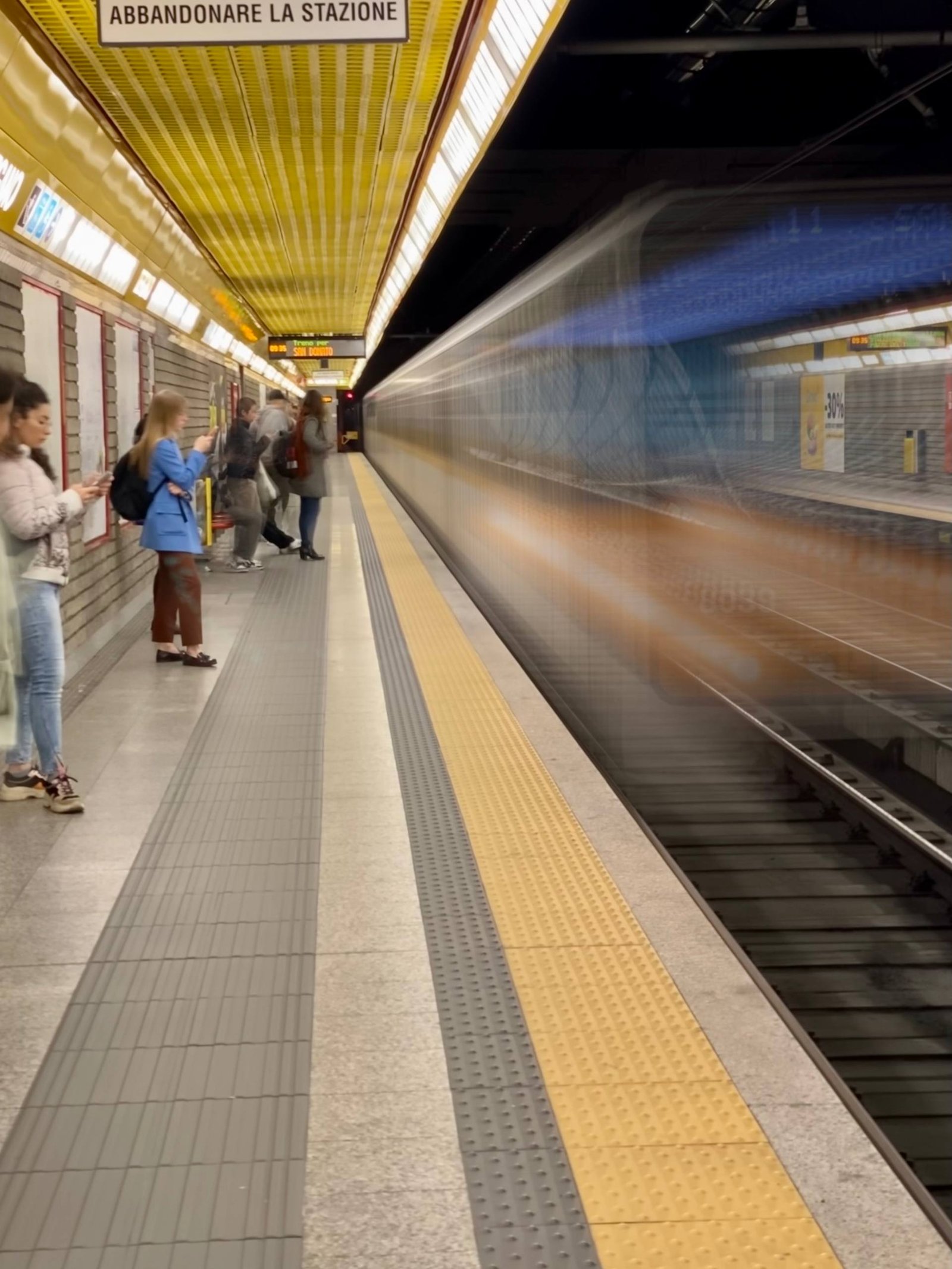 people standing in metro station while metro arriving